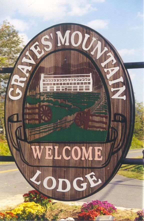 A large wooden oval sign with a rustic design reads 