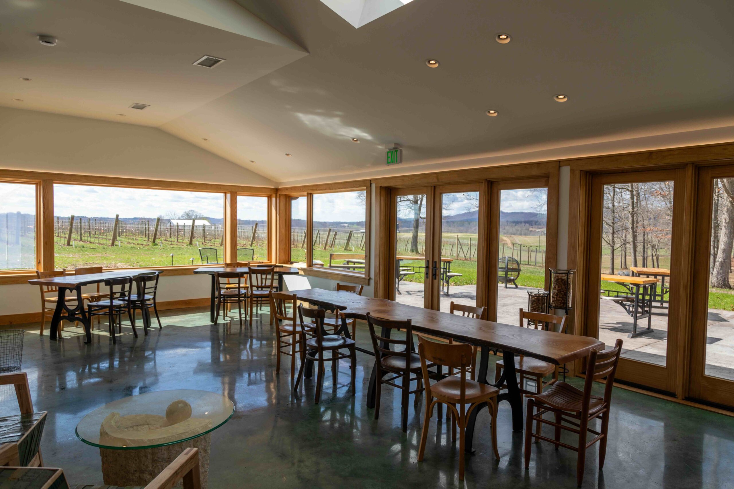 inside a modern wine tasting room with big windows and mountain views