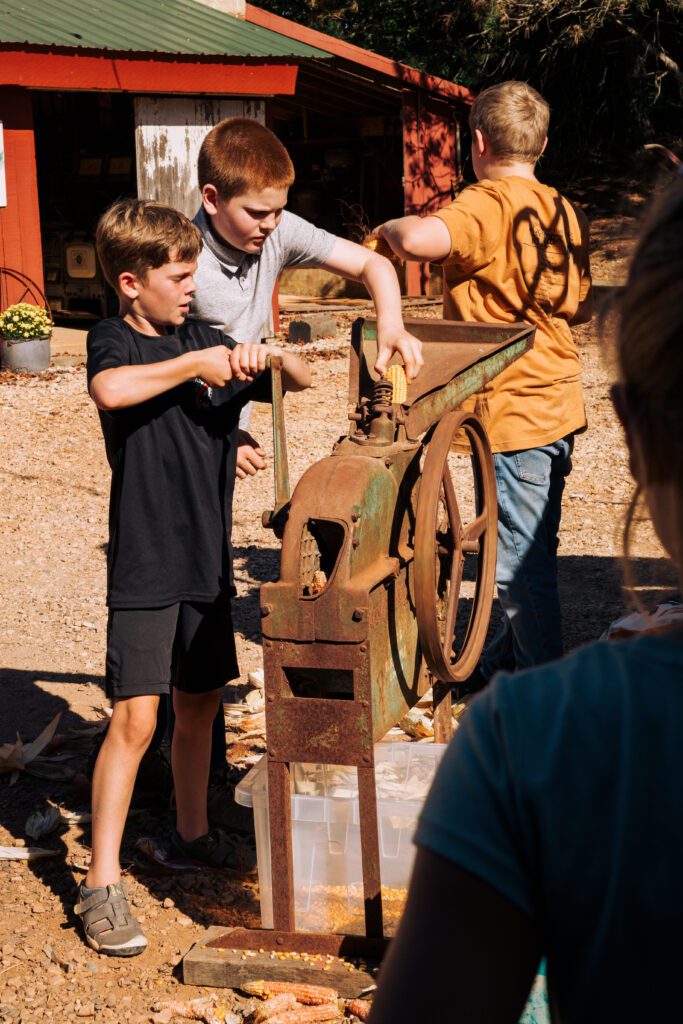 Kids grinding corn on farm