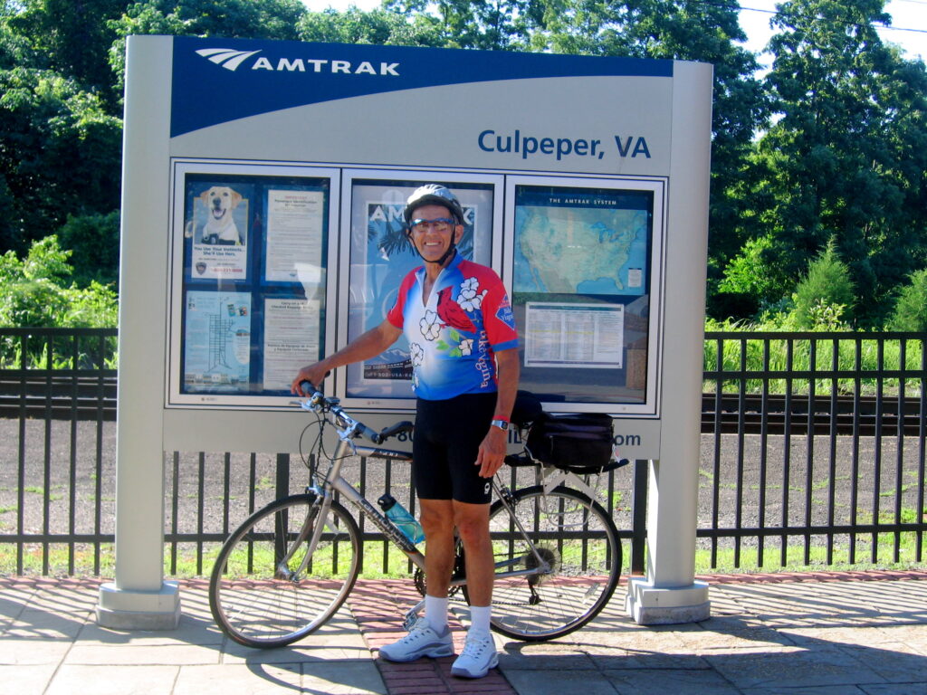 Biker standing beside sign