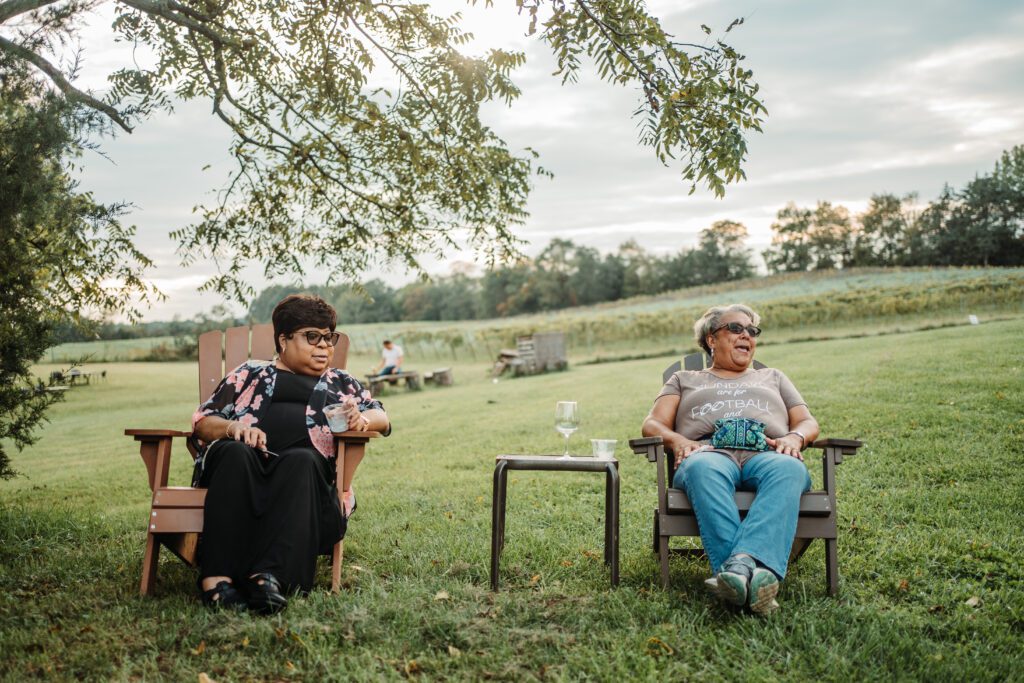 two women sitting and talking at a winery