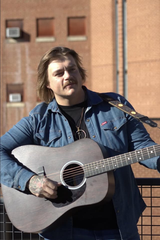 male holding a guitar