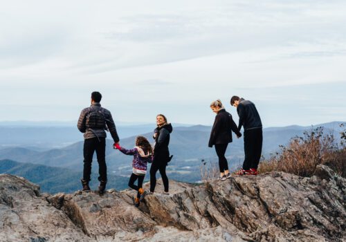 Family of 5 standing on a mountain overlook