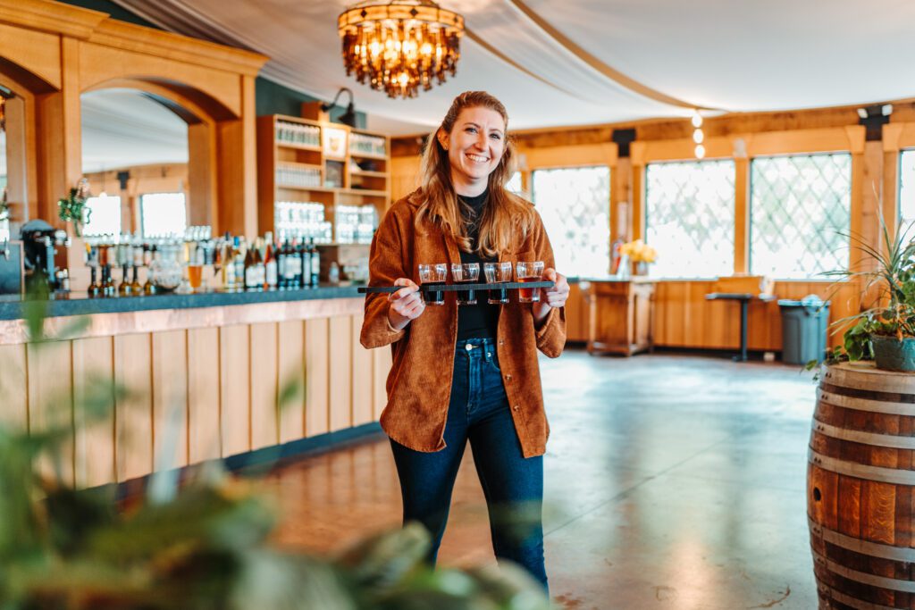 woman carrying a flight of beer