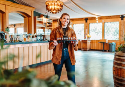 woman carrying a flight of beer