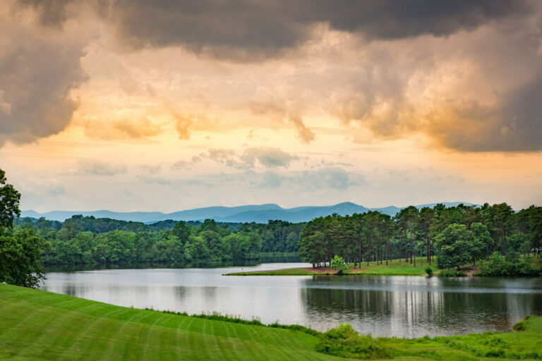 lake view with mountains in the background as the sun sets