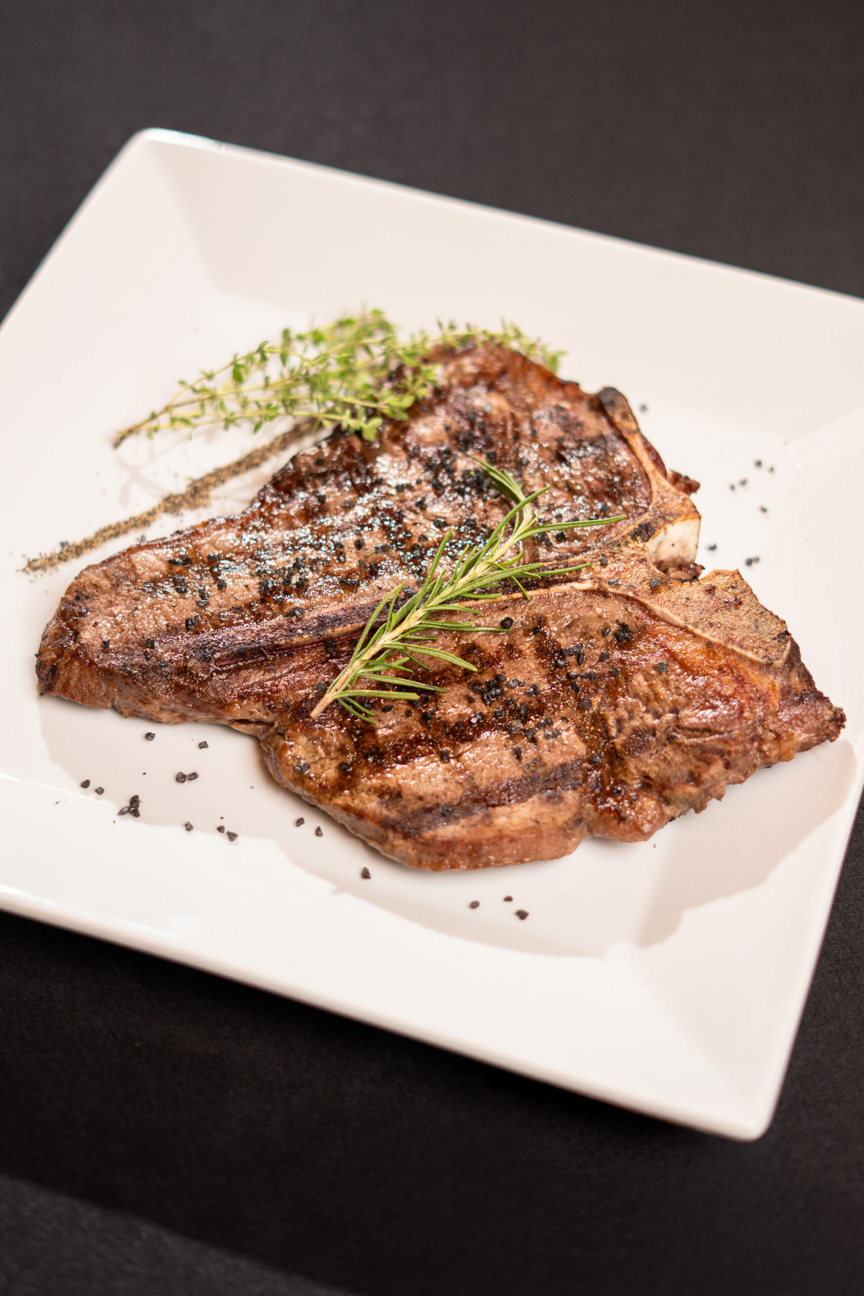 steak on a white plate with green garnish